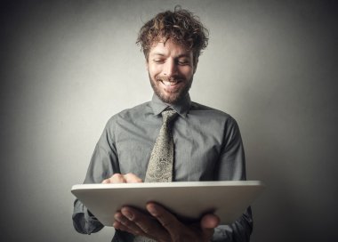 Gülümseyen iş adamı tablet kullanıyor.