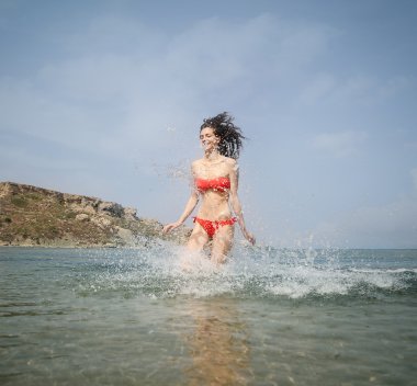 Genç kadın sahilde su atlama