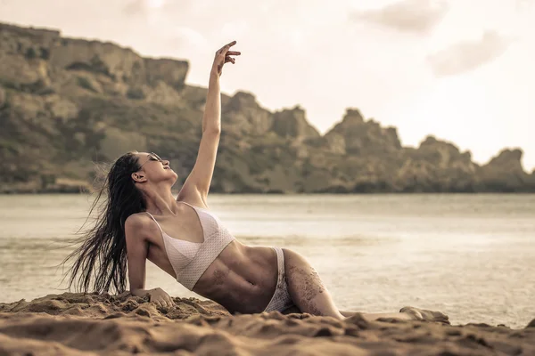 Mooie vrouw liggen op het strand — Stockfoto