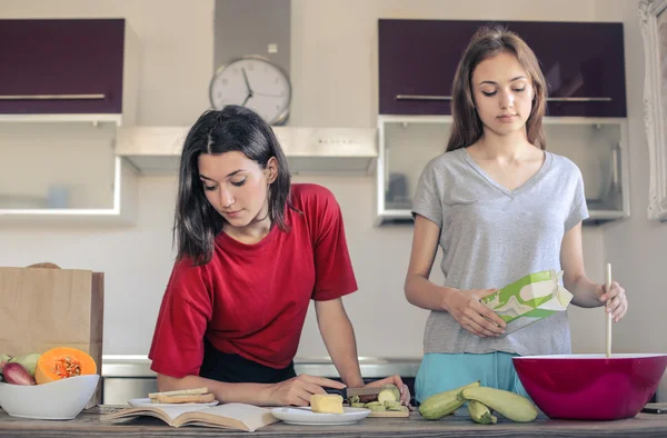 Två flickor matlagning mat — Stockfoto