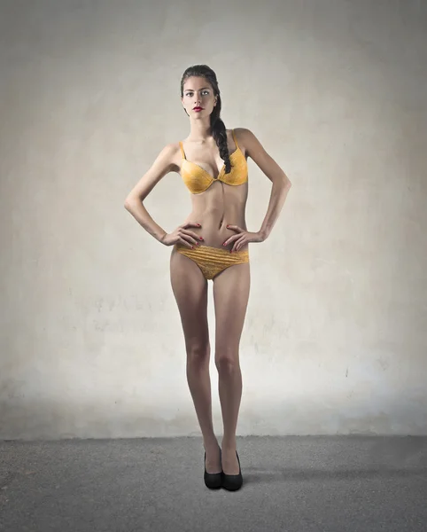 Beautiful woman wearing a yellow swim suit — Stock Photo, Image