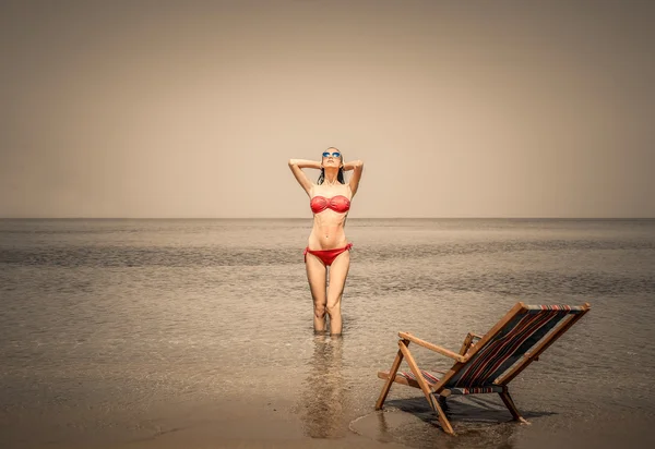 Mulher bonita de pé na água na praia — Fotografia de Stock