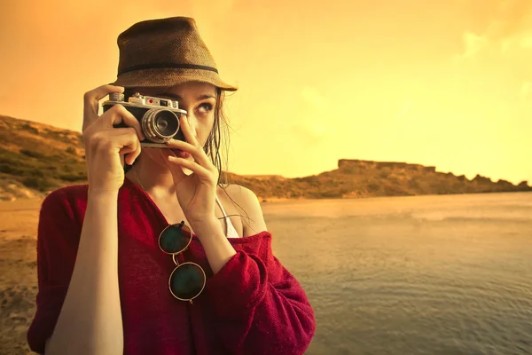 Young woman taking a picture at the seaside — Stock Photo, Image