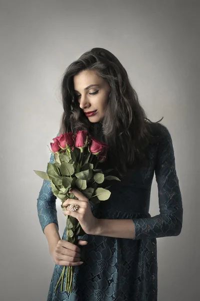Frau mit roten Rosen in der Hand — Stockfoto