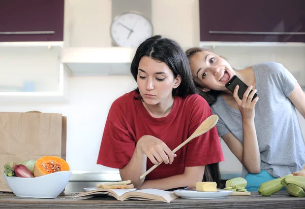 Bored and happy girls in the kitchen — Stock Photo, Image