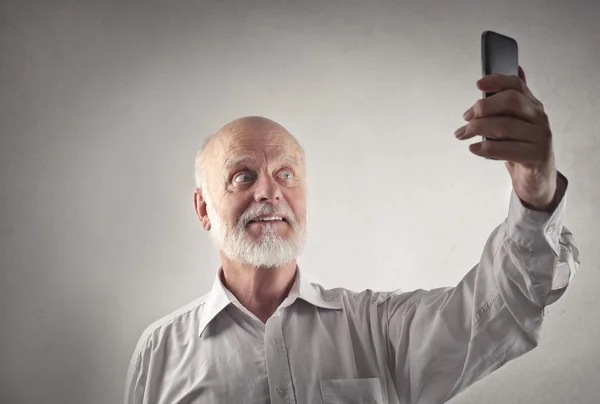 Äldre man gör en selfie — Stockfoto