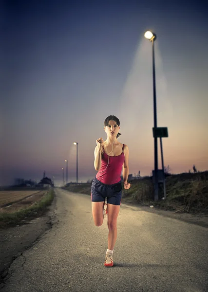 Athlete running at night — Stock Photo, Image