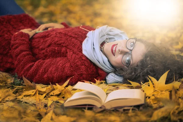 Frau liegt auf einigen Blättern — Stockfoto