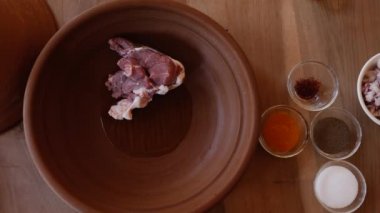 Bir kuzu, koyun eti, koyun eti tavernası, Fas kil tenceresinde tagine hazırlamak, eti eklemek. Geleneksel Fas ağır ateşte pişmiş yemekleri.