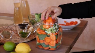 Bir kavanozu havuç ve brokoli ile doldurmak, elma sirkesiyle su eklemek. Fermente ediyor, sebzeleri koruyor. Probiyotik ve prebiyotik gıdalar, sağlıklı bir bağırsak için iyi bakteri açısından zengin. Yavaş çekim.