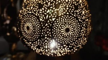 Aydınlatılmış, Fas malı, Arap pirinçten bir lamba ve karmaşık bir çiçek deseni. Fas ve Arap lamba tasarımı kavramı. Lambanın içindeki deseni yakınlaştırıyorum..
