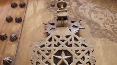 Geleneksel Fas İslami geometrik şekil tasarımında demir pirinç kapı tokmağı. Karmaşık el yapımı metaller.