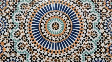 Colorful zellige pattern in traditional Islamic geometric design from a public fountain in Marrakech, Morocco. Made with natural colors from indigo, saffron, mint, kohl. Camera movement zooming in.