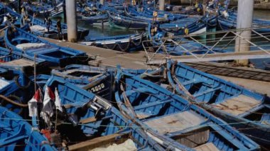 Essaouira limanında eski, ahşap, mavi balıkçı tekneleri suda sallanıyor. Balıkçılık endüstrisi. Turizm, Fas 'ta seyahat beldesi.