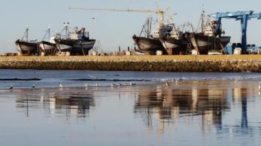 Essaouira 'da eski gemilerle sahil ve liman. Balıkçı tekneleri, nakliye gemileri. Fas 'ın turistik seyahat beldesi.