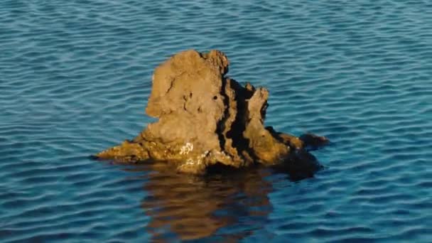 Rock Met Reflectie Kabbelend Bewegend Saffierblauw Zeewater Contrast Van Een — Stockvideo