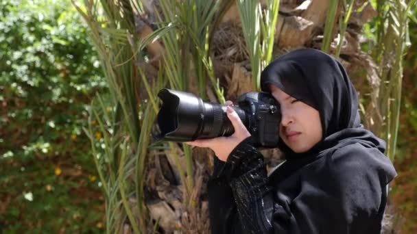 아름다운 모로코 이슬람 여성이 Dslr 카메라를 정원에서 촬영을 실시간 영상입니다 — 비디오