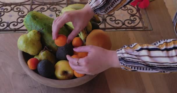女性は有機新鮮な果物 オレンジ バナナ リンゴ マンゴー パパイヤ アプリコット アボカドとフルーツボウルに果物を配置します 健康的な食品や健康的なライフスタイルのための概念 リアルタイムの映像 — ストック動画