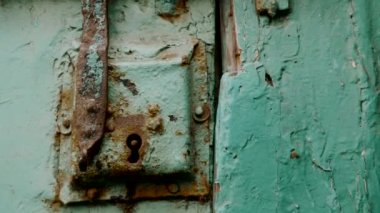 Old, rusty, wooden, mint green door with lock, in Essaouira, Morocco. Close-up vintage footage.
