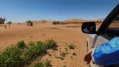 Four-wheel vehicle car drives off-road in the Sahara desert of Morocco. View of the Erg Chagaga sand dunes. 4k