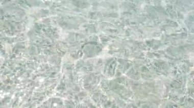 Havuzda parlak, pürüzsüz, parlak su ve güneş yansımaları. Soyut arkaplan görüntüleri.