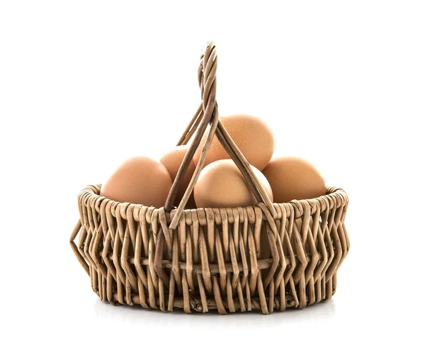 Ovos em uma cesta de vime em um fundo branco — Fotografia de Stock