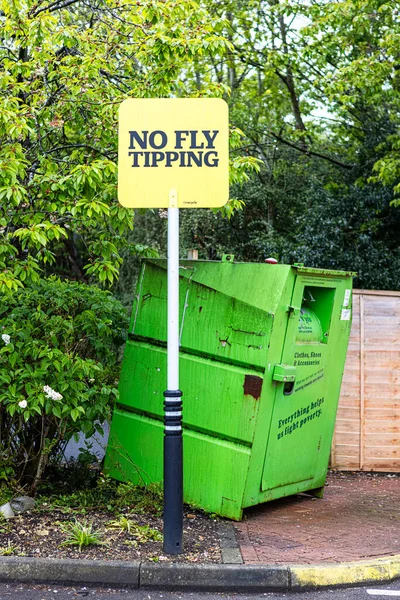 Желтая Вывеска Надписью Fly Tipping Рядом Зеленым Мусорным Баком — стоковое фото