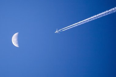Parlak mavi karşı ay geçmiş uçan uçak