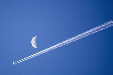 Geçmiş ay parlak mavi gökyüzü uçan uçak
