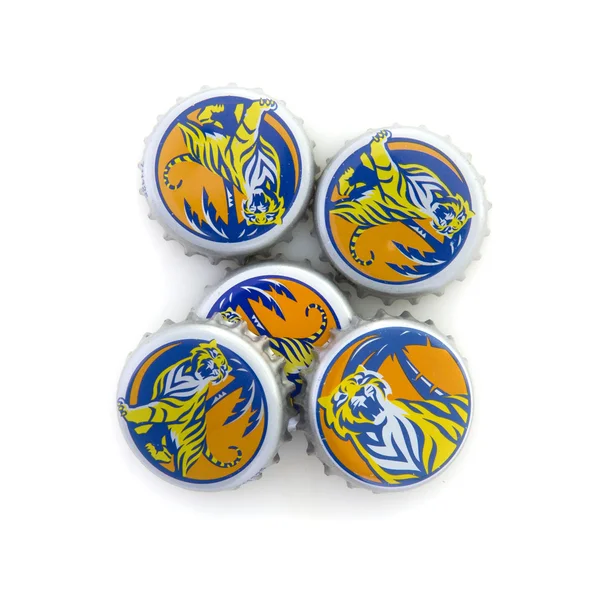 Högen av Tiger Beer Bottle Tops på vit bakgrund — Stockfoto