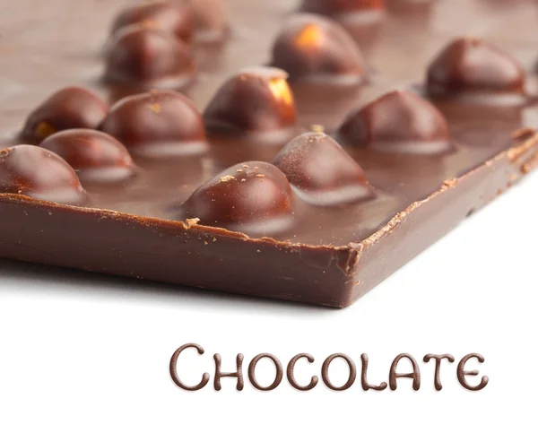 Chocolate inteiro com fundo de nozes — Fotografia de Stock