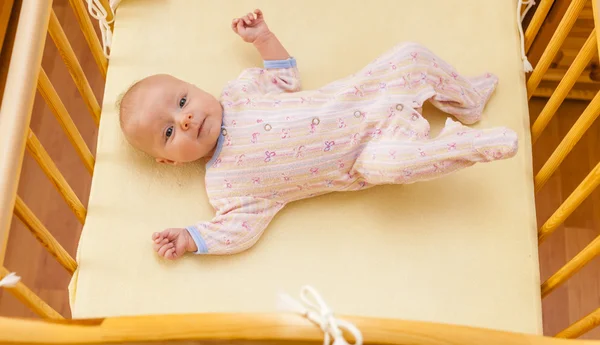 Lying two month old baby girl in cot — Stock Photo, Image