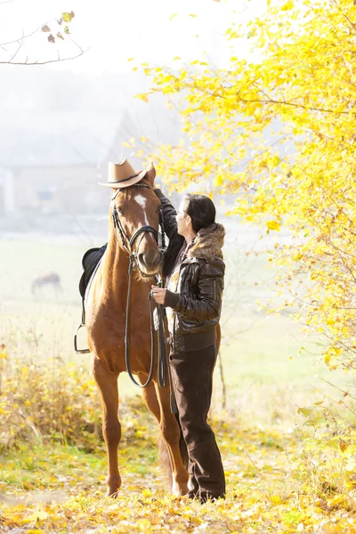 Jeździec ze swoim koniem w jesiennej naturze — Zdjęcie stockowe