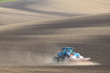 İlkbahar başlarında tohum matkabıyla traktör.