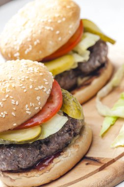 Salatalık ve domatesli ev yapımı hamburger.