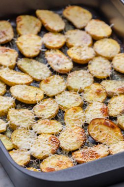 Rendelenmiş peynirle pişirilmiş patates dilimleri