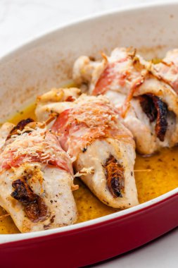 Domuz pastırmasında kurutulmuş domatesle doldurulmuş tavuk dürümü.