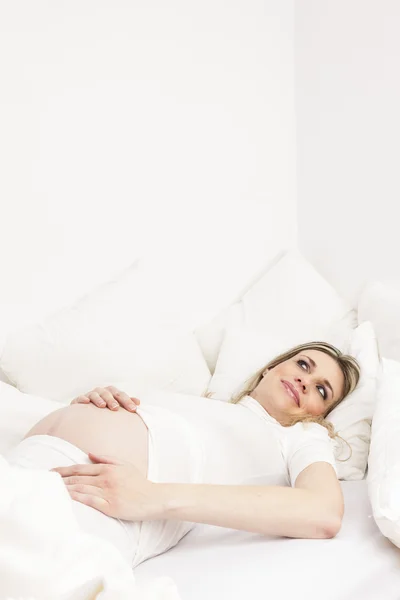 Femme enceinte se reposant au lit — Photo