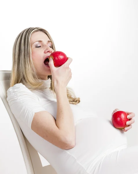 Portrait of pregnant woman eating red apple — Stock Photo, Image