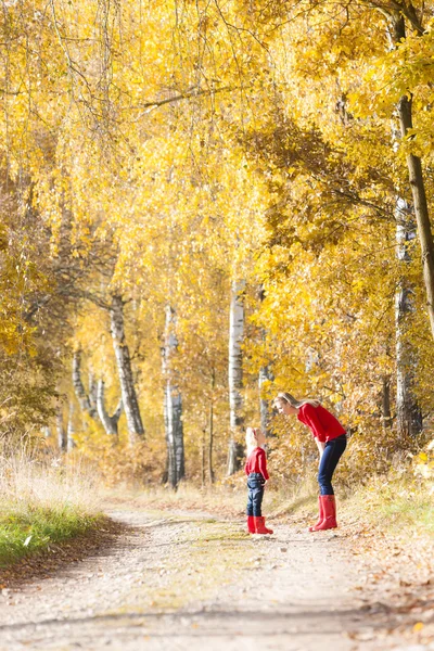 Moeder met haar dochter in herfst steegje — Stockfoto