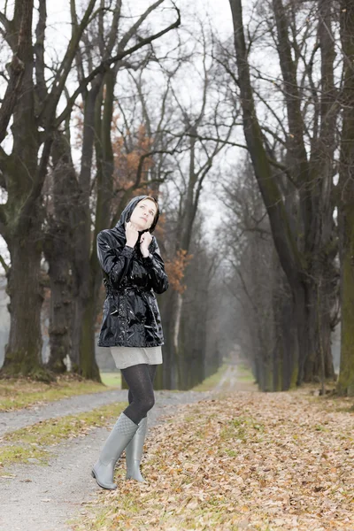 Frau trägt Gummistiefel in herbstlicher Gasse — Stockfoto