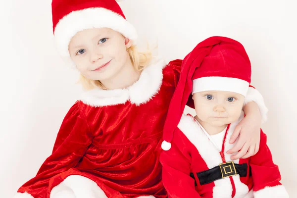 Zwei kleine Mädchen als Weihnachtsmänner — Stockfoto