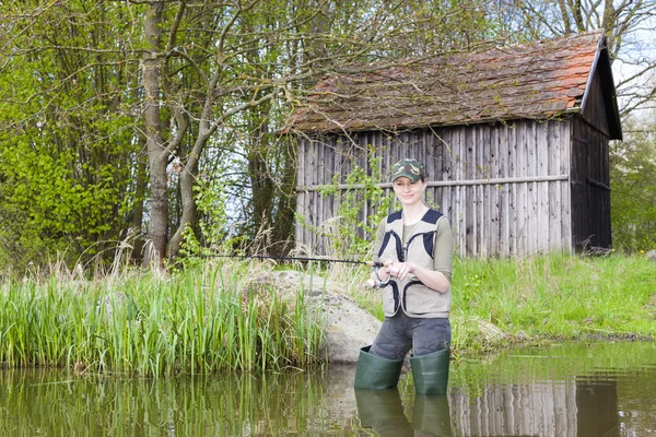 Woman fishing in pond in spring — Stock Photo, Image