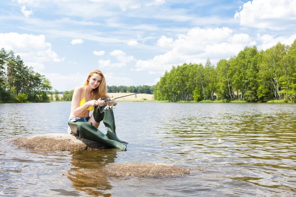 Mladá žena ryby v rybníku v létě — Stock fotografie