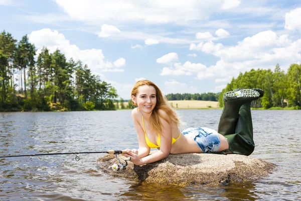 Mujer joven pescando en el estanque durante el verano — Foto de Stock