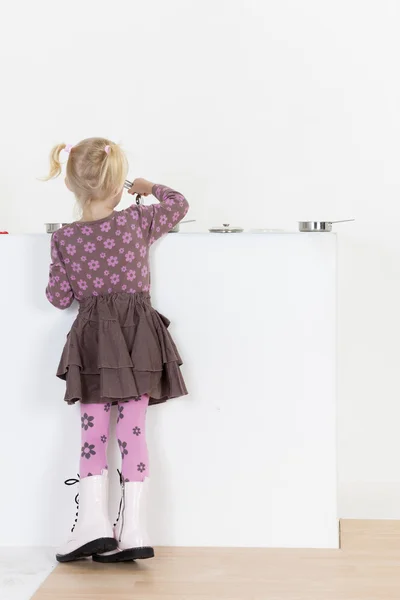 Little girl playing with child dish — Stock Photo, Image