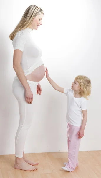 Little girl with her pregnant mother — Stock Photo, Image