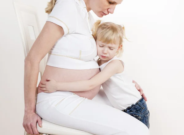 Meisje met haar zwangere moeder — Stockfoto