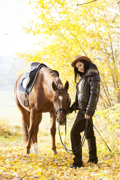 Ridsport med sin häst i höst natur — Stockfoto