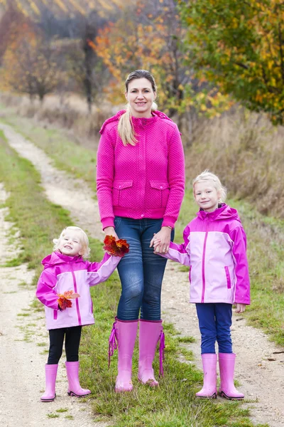 Mamma och hennes döttrar i höstliga naturen — Stockfoto